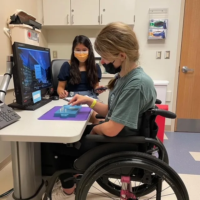 Child in wheelchair in front of computer