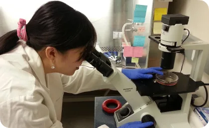 A woman looking through a microscope